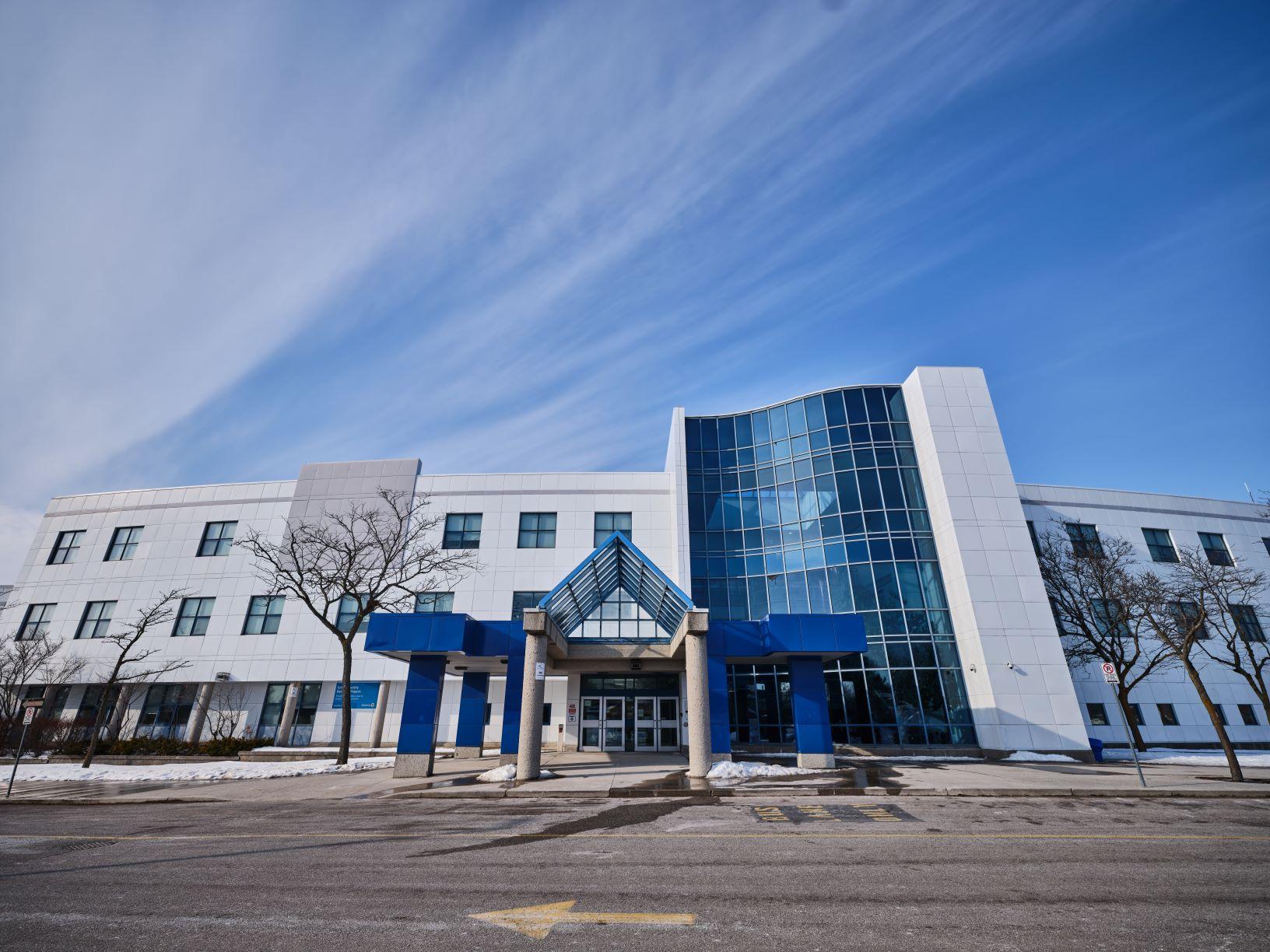white multi-storey school building with tall section of glass windows